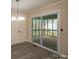 Open dining space with a glass sliding door to the screened in porch and a modern chandelier at 833 E Chestnut St, Stanley, NC 28164