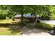 Charming brick home with a metal roof, covered porch, mature trees and spacious driveway at 833 E Chestnut St, Stanley, NC 28164
