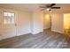 Bright living room featuring a ceiling fan, new gray flooring, and a view to the bathroom at 833 E Chestnut St, Stanley, NC 28164