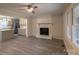 Open-concept living room with a fireplace, ceiling fan, and views into the kitchen at 833 E Chestnut St, Stanley, NC 28164