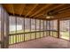 Enjoy the view in a screened-in porch featuring wood flooring, fan, and backyard access at 833 E Chestnut St, Stanley, NC 28164