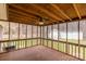Screened-in porch boasts wood-beamed ceilings, fan, and views of the backyard and storage shed at 833 E Chestnut St, Stanley, NC 28164