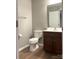 Bathroom featuring dark cabinets, laminate flooring, and a large mirror at 11724 Blessington Rd, Huntersville, NC 28978