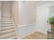 Bright foyer featuring a staircase with natural wood steps and a white front door at 119 Winterberry St, Mooresville, NC 28117