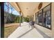 Spacious covered patio with neutral colors, outdoor seating, ceiling fan and view of the landscaped yard at 148 Castle Dr, Mooresville, NC 28117