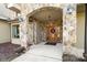 Covered front entrance featuring stone archway, wood door with wreath, and pendant lighting at 148 Castle Dr, Mooresville, NC 28117