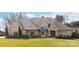Stone-accented home showcasing a well-manicured lawn, mature trees, and a welcoming facade at 148 Castle Dr, Mooresville, NC 28117