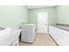 Bright laundry room with modern washer and dryer, ample counter space, and utility sink at 148 Castle Dr, Mooresville, NC 28117