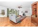 Bright living room with hardwood floors, a ceiling fan, fireplace, and large sliding glass door leading to a wooded backyard at 148 Castle Dr, Mooresville, NC 28117