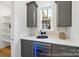 Stylish bar area with gray cabinets, a wine cooler, and a view to the outside at 19155 Newburg Hill Rd, Davidson, NC 28036