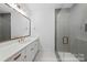This contemporary bathroom has a large vanity with stone countertop and a tiled walk-in shower at 19155 Newburg Hill Rd, Davidson, NC 28036