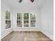 Bright room featuring hardwood floors, white walls, and a view of the wooded lot behind the home at 19155 Newburg Hill Rd, Davidson, NC 28036