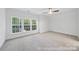 This bedroom is filled with natural light, with large windows offering expansive wooded views at 19155 Newburg Hill Rd, Davidson, NC 28036
