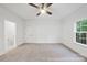 This bedroom features neutral carpeting, a ceiling fan, and natural light streaming through the window at 19155 Newburg Hill Rd, Davidson, NC 28036