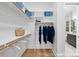 Walk-in closet with custom shelving, hanging racks, wood floors and a bathroom view at 19155 Newburg Hill Rd, Davidson, NC 28036