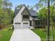 Beautiful two-story home featuring a white facade, a two-car garage and lush green landscaping at 19155 Newburg Hill Rd, Davidson, NC 28036