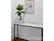 Foyer features plant atop marble table with black trim and blue and tan artwork at 19155 Newburg Hill Rd, Davidson, NC 28036