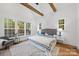 Bright main bedroom boasts vaulted ceilings, exposed beams, and several windows with views at 19155 Newburg Hill Rd, Davidson, NC 28036