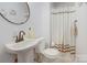 Clean bathroom with a pedestal sink, shower, and updated fixtures at 2004 Grandhaven Dr, Concord, NC 28027