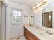 Bright bathroom featuring double sink vanity, mirror, and an adjacent room at 2050 Tite Rd, Stanfield, NC 28163