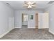 Carpeted bedroom featuring a ceiling fan, multiple doorways, and white trim at 2050 Tite Rd, Stanfield, NC 28163