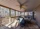 Relaxing covered porch with outdoor seating, ceiling fans, and view of wooded backyard at 2050 Tite Rd, Stanfield, NC 28163
