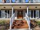 Inviting front porch with brick steps, white railings, and a classic wooden front door with glass detailing at 2050 Tite Rd, Stanfield, NC 28163