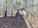 Weathered wood outbuilding surrounded by mature trees and a leaf-covered ground at 2050 Tite Rd, Stanfield, NC 28163