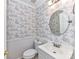 Charming powder room with decorative wallpaper, oval mirror and traditional fixtures at 2050 Tite Rd, Stanfield, NC 28163