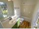 Updated bathroom with green vanity, white fixtures, and wood-look flooring at 257 Doughton Ln, Charlotte, NC 28217