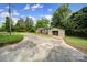 Home with detached garage and a concrete driveway amidst a yard with shrubbery and lush greenery at 2988 Great Falls Hwy, Lancaster, SC 29720