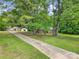 View of the driveway leading to the brick home, surrounded by lush greenery and large trees at 2988 Great Falls Hwy, Lancaster, SC 29720