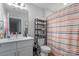 Bathroom featuring a sink, toilet and shelf holding towels with a rainbow curtained shower at 305 Wingate Ct, Shelby, NC 28152