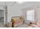 Charming bedroom featuring a gold crib with soft textures and a bright window with lace curtains at 305 Wingate Ct, Shelby, NC 28152