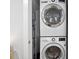 A stacked white washer and dryer setup, with visible water heater and an ironing board at 305 Wingate Ct, Shelby, NC 28152