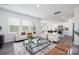 Bright living room with stylish decor, including modern furniture, large windows, and an open layout with a view of the kitchen at 321 Brinkley Dr, Kings Mountain, NC 28086