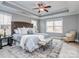 Spacious main bedroom featuring a tray ceiling, a tufted headboard, and a cozy sitting area at 3704 Bronte Ln, Monroe, NC 28110