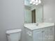 This bathroom features a white vanity, toilet and a large mirror at 5707 Brandy Ridge Ln, Charlotte, NC 28269