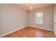 Bright bedroom featuring wood laminate floors, a chandelier, and natural light at 5707 Brandy Ridge Ln, Charlotte, NC 28269