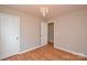 This bedroom features wood laminate floors, a light fixture, and painted walls at 5707 Brandy Ridge Ln, Charlotte, NC 28269