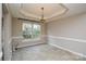 Dining room with decorative chandelier, tray ceiling and neutral paint at 5707 Brandy Ridge Ln, Charlotte, NC 28269