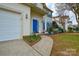 Inviting entrance featuring a blue door, well-maintained landscaping, and a sidewalk to the front door at 5707 Brandy Ridge Ln, Charlotte, NC 28269