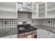Kitchen with stainless steel range, granite countertops, white cabinets and black and white tile backsplash at 5707 Brandy Ridge Ln, Charlotte, NC 28269