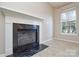 Bright living room featuring a fireplace with black marble surround and a large window at 5707 Brandy Ridge Ln, Charlotte, NC 28269