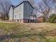 Back exterior view of home with porch, yard, and brick base at 613 S Mulberry St, Statesville, NC 28677
