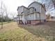 Back exterior view of home with porch, yard, and brick base at 613 S Mulberry St, Statesville, NC 28677