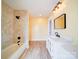 Modern bathroom with marble-look shower/tub, single sink vanity with decorative doors, and updated light fixtures at 613 S Mulberry St, Statesville, NC 28677