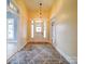 A well-lit foyer featuring a patterned rug, a white front door, and access to other rooms at 613 S Mulberry St, Statesville, NC 28677