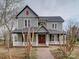 Charming two-story home with a covered front porch and a red front door at 613 S Mulberry St, Statesville, NC 28677