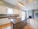 Elegant kitchen boasts a large island, white cabinets, stainless steel sink, and modern pendant lighting fixtures at 613 S Mulberry St, Statesville, NC 28677